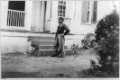 J.H. Wilson, full-length portrait, standing, facing left; in front of building