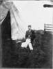 Capt. Huff's clerk, full-length portrait, seated, facing left, in front of tent, holding book