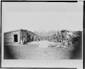 Union soldiers, in camp, posed in front of log buildings